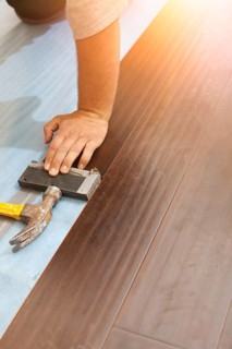 Man installing new laminate wood flooring abstract