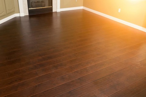 Beautiful newly installed brown laminate flooring and baseboards in home