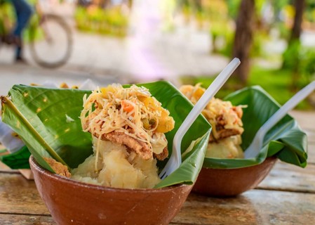 Vigoron with leaves served on a wooden table