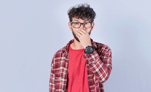 Close up of a man covering his nose