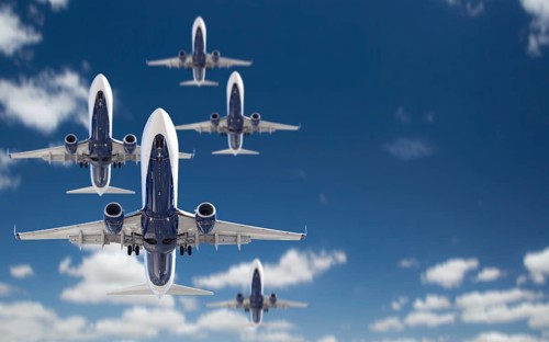 Bottom view of several passenger airplanes flying in the blue sky