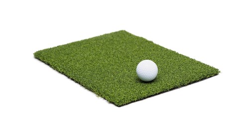 Golf ball resting on section of artificial turf grass on white background