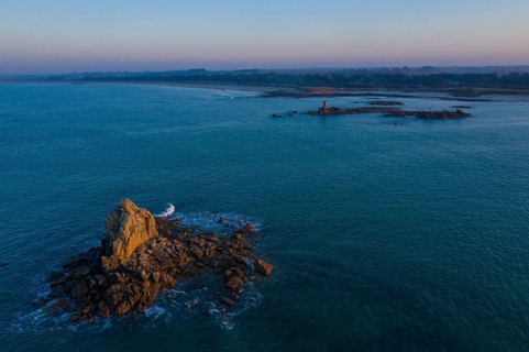 Aerial view of rock formations in the sea in front of the sandy beach Ker Emma shortly in front of sunset