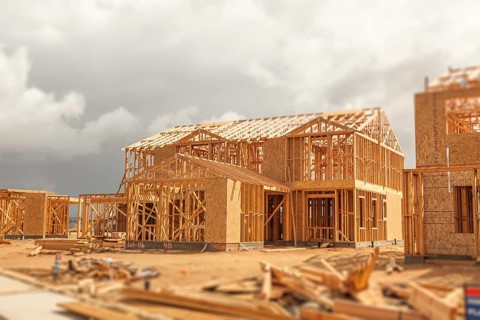 Wood home framing abstract at construction site with stormy clouds behind