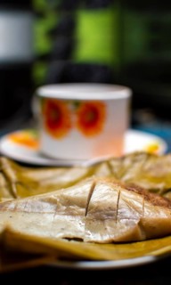 Stuffed tamale served on wooden table