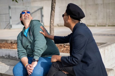 Gay Latino male couple sitting on a bench in a park
