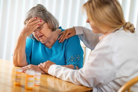 Female doctor consoling distraught senior adult woman