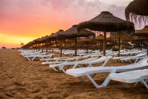 Beautiful colorful sunset over sun beds and umbrellas in Vilamoura