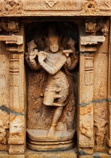 Krishna playing flute bas relief in Hindu temple