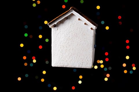 Little model house on a bokeh ligh ton a dark background