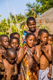 Children watch with interest at traditional customs in real African village