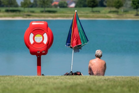 A man sits on the bank of the Kronthaler Weihers in Erding
