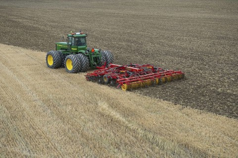 John Deere 9400 pulling Vaderstad TopDown 700 cultivator and tilling stubble field
