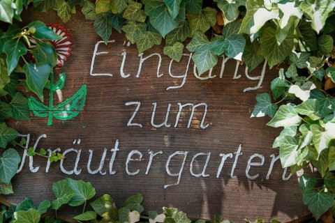 Handgeschriebenes Schild Eingang zum Kraeutergarten