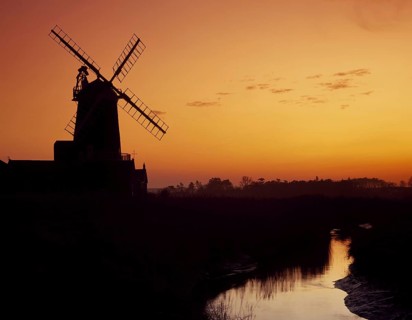 Windmill silhouetted at sunset