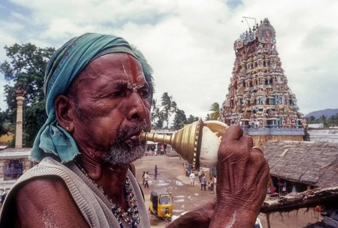 Sadhu blowing conch standing infornt of Nataraja temple in Perur near Coimbatore