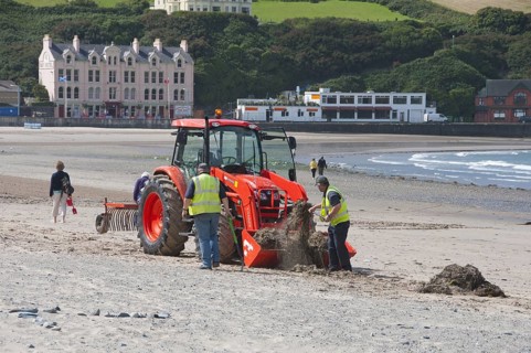 Workers with tractor on beach