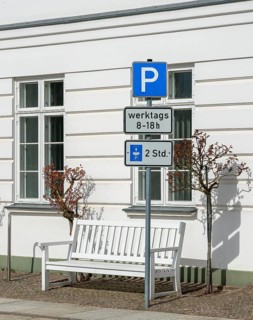 Traffic sign for temporary parking in front of white house wall