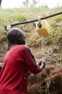 Child washes hands under self-made tap