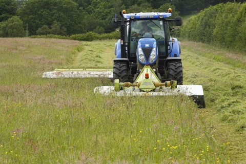 Contractor with New Holland T6080 tractor with front and rear mounted Claas mowers