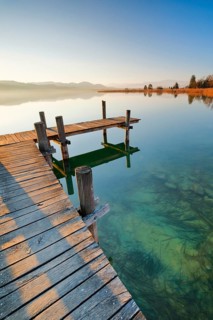 Holzsteg am Pfaeffikersee bei Sonnenaufgang mit Blick zum Bachtel und Glaernisch im Hintergrund