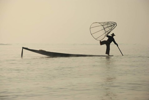 Traditional fisherman with fish trap in boat