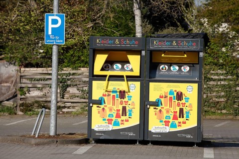Used clothing container for clothes and shoes in a car park