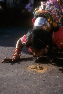 A folk dancer lifting the needle from the floor by the eye lashes during Pongal festival celebration at Madurai