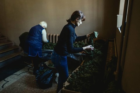 Women and young people tie camouflage nets in the youth and children's library