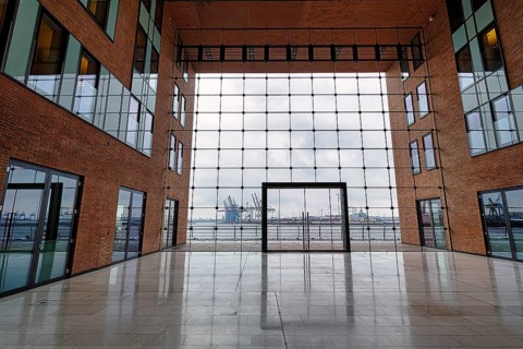 View through modern glass facade with large door onto the harbour