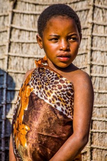 Children watch with interest at traditional customs in real African village