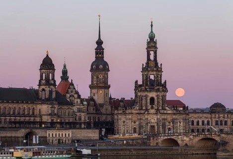 Full moon behind the silhouette of the old town with the towers of the Staendehaus