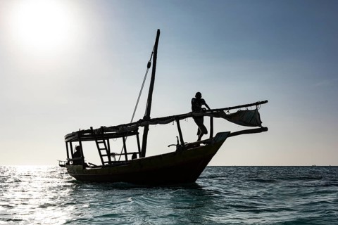 Silhuette von Fischerboot und Fischer