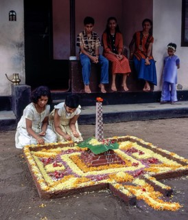 Girls doing floral decoration or pookalam during Onam festival in Kodungallur