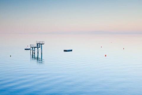Morgenstimmung ueber dem Bodensee mit Blick zum Sprungturm und den Flossen der Freibadanlage Horn inmitten des Sees