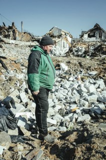 Serhiy Melnyk stands on the ruins of his house in the residential district of Bohunia