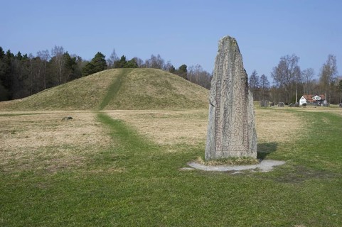 Rune stone beside ancient tumulus