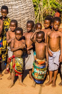 Children watch with interest at traditional customs in real African village