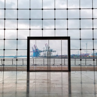 View through modern glass facade with large door onto the harbour