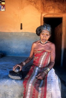 Mudunga tribal old lady sitting in front of the hut