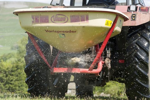 Fertiliser application in a traditional Dales meadow with a Case International tractor. Hawes