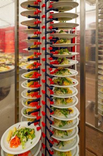 Stacked plates of mixed salad with sliced cheese and sprouts