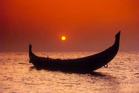 The Setting sun framed by the crescent shaped stern of a Catamaran in Kozhikode