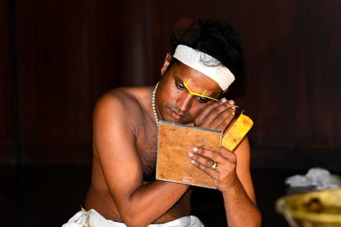 Kathakali dancer putting on make-up