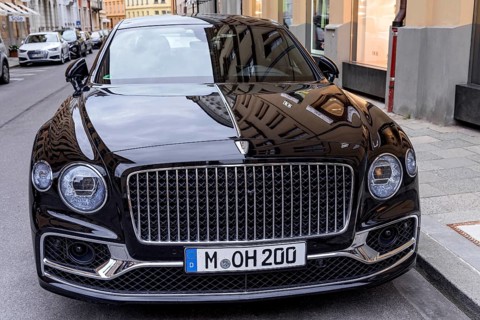 Parked luxury sedan Bentley Flying Spur First Edition in front of fashion shop Boutique Dior
