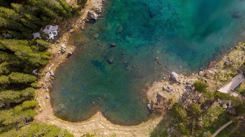 View of of turquoise blue water of Lago di Carezza and Latemar Group mountains