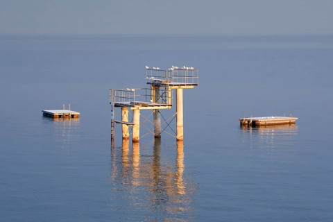 Morgenstimmung ueber dem Bodensee mit Blick zum Sprungturm und den Flossen der Freibadanlage Horn inmitten des Sees