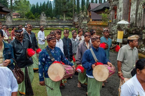 Balinese musicians carrying traditional instruments in procession