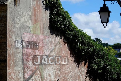 Old advertisement of a wine shop painted on a house wall
