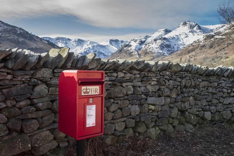 Royal Mail letterbox beside a dry stone wall